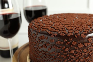 Delicious chocolate truffle cake and red wine on table, closeup
