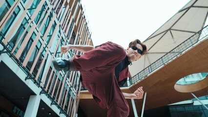 Low angle of asian attractive hipster pose at camera surround by mall. Portrait of break dance...