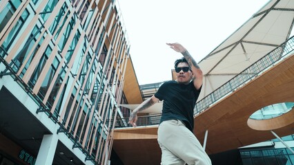 Young hispanic break dancer dance at camera with low angle camera. Portrait of enthusiasm mexican...