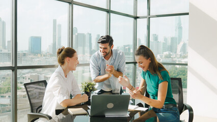 Professional business team receive a good news by using laptop while celebrate their success....