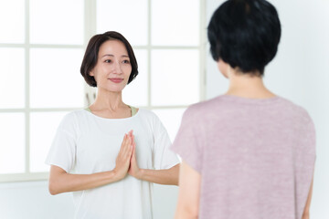 Obraz premium スポーツジムでヨガをするミドル女性