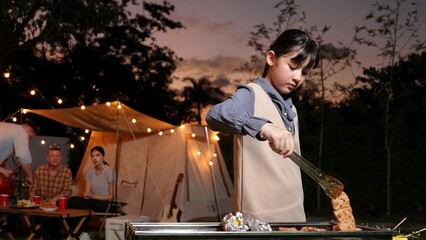Family gather celebrate holiday, Adorable child grill food for family member. Outdoor camping activity to relax with tasty meal and spend time with young generation cross generation gap. Divergence.