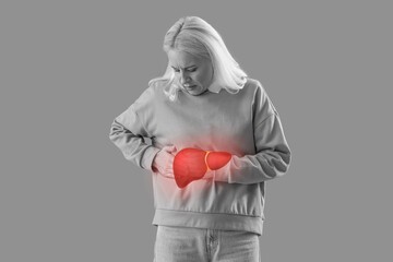 Mature woman suffering from side pain on green background