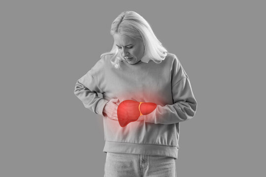 Mature woman suffering from side pain on green background