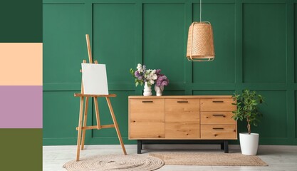 Stylish wooden cabinet, easel and vase with flowers near green wall in room. Different color...