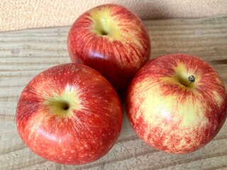 木のテーブルにのった３個のりんご