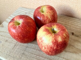 木のテーブルにのった３個のりんご