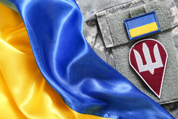 Military uniform with badge of Ukrainian army and flag of Ukraine, closeup