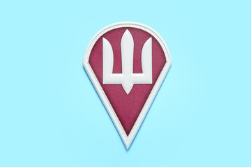 Military badge of Ukrainian army with trident on turquoise background
