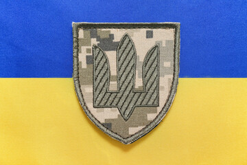 Military badge with trident on flag of Ukraine, closeup