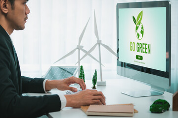 Businessman working in office developing plan or project on eco-friendly alternative energy with...