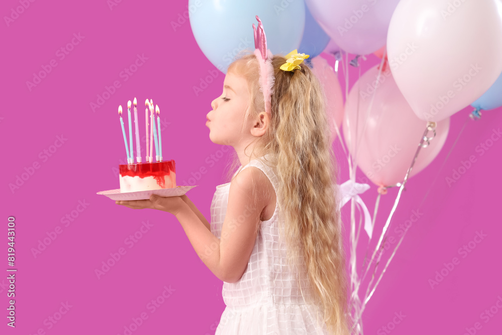 Poster cute little girl blowing candles on birthday cake and balloons against purple background