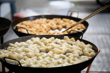 Hand made chinese Fried Dough cooking in a pan.