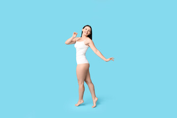 Body positive woman in underwear posing on blue background