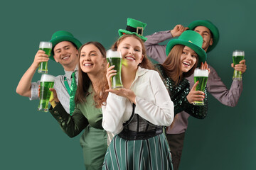 Group of young friends with beer on green background. St. Patrick's Day celebration