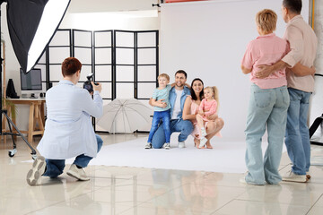 Parents with their little children having photo shoot in studio
