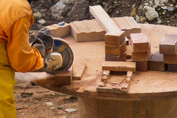 A man is cutting bricks with a saw