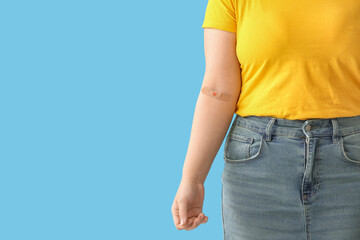 Blood donor with applied medical patch on blue background
