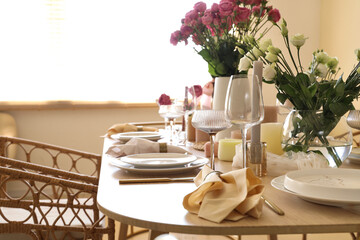 Beautiful table setting with flowers and candles for wedding celebration in room, closeup