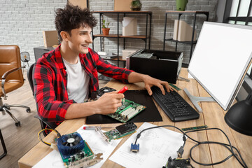 Male technician repairing computer at table in service center