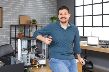 Male technician repairing PC unit in service center