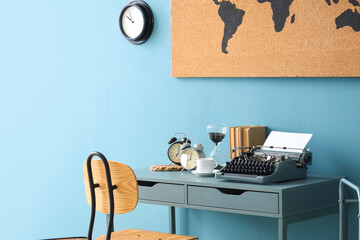 Vintage typewriter with coffee cup, alarm clocks and books on table in office