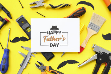Tools and greeting card with text HAPPY FATHER'S DAY on yellow background