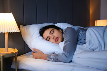 Beautiful young woman sleeping in bedroom at night