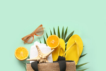 Composition with stylish beach accessories, palm leaf and orange on color background