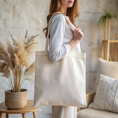 Tote bag mockup. Woman carrying reusable white cotton linen eco organic fabric canvas blank totebag on soft earth tone cozy room background. AI generated