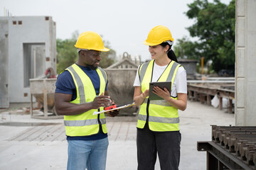Portrait African engineer man use clipboard and Hispanic latin engineer woman use tablet computer checking precast cement at precast cement outdoor factory	