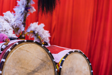 Dhak is a special drum or musical instrument played during durga puja festival. dhaks are kept together against red background.