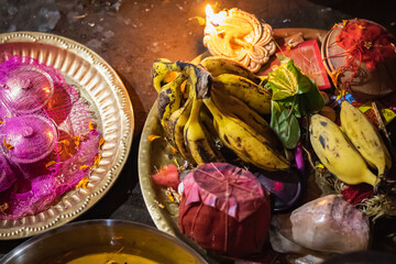 Religious items on boron dala or copper plate for hindu puja rituals during performing of the rites. Oil lamp and banana and betel leaves are symbolic to traditional hindu culture 