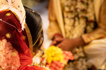 Hindu traditional marriage rites being performed with bride and groom sitting together in presence...