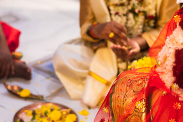 Hindu traditional marriage rites being performed with bride and groom sitting together in presence...