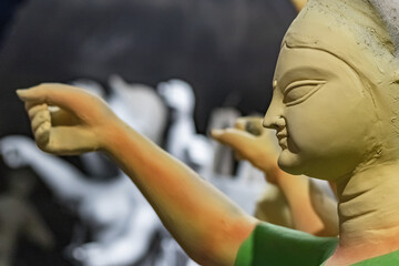 goddess durga idol during durga puja festival. The unfinished idol is made of clay being sculpted.
