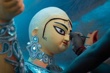 Goddess Durga idol's eyes being painted for Durga puja festival during mahalaya at kumartuli. This...