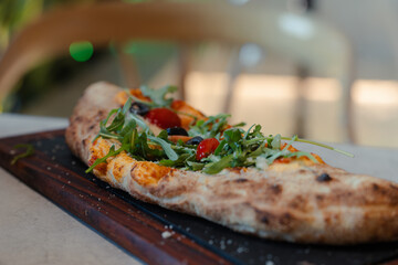 Fresh fire stone oven-baked pizza calzone with veggies 