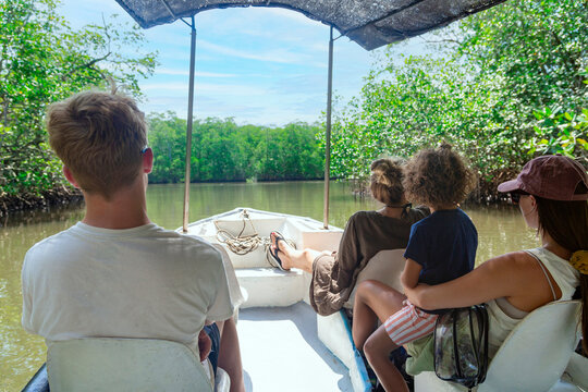 View from behind of a Family on a wildlife estuary boat tour in Costa Rica. Exploring the Tamarindo estuary and river area looking for wildlife and the mangrove forests. Costa Rican Travel photo