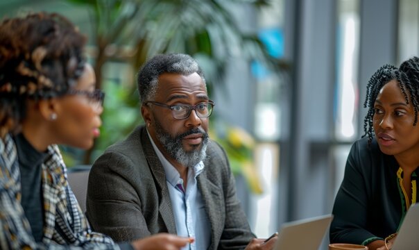 group of african american people colleague discussing in a meeting. wearing blazer and suit shirt.