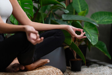 Young woman doing morning yoga and meditation in natural garden with plant leaf, enjoying the...