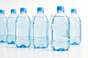 Row of Plastic Water Bottles on White Background