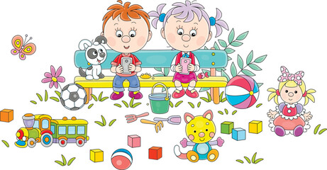 Funny little girl and boy with a puppy sitting on a bench in a summer park and playing their smartphones among toys scattered around, vector cartoon illustration on a white background