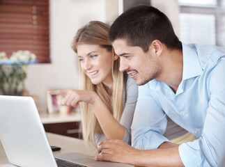 Couple, home and computer for reading news, planning and online shopping in kitchen with choice....