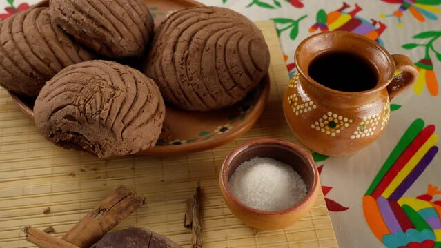 delicious chocolate conchas on a clay plate with a cup of hot coffee