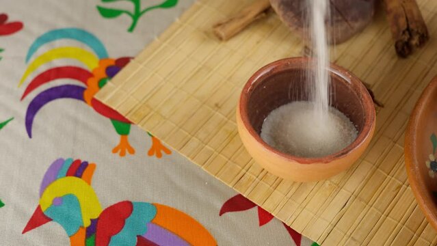 Dropping sugar on mexican clay bowl