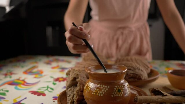 Milk on a mexican clay jar, front view slow motion