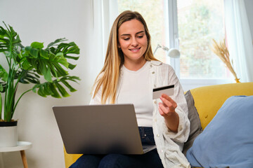 Caucasian young woman buying online with a credit card in her laptop at home. Black Friday sales.