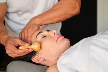 Woman getting face maderotherapy in a beauty salon. Professional skin care treatment.