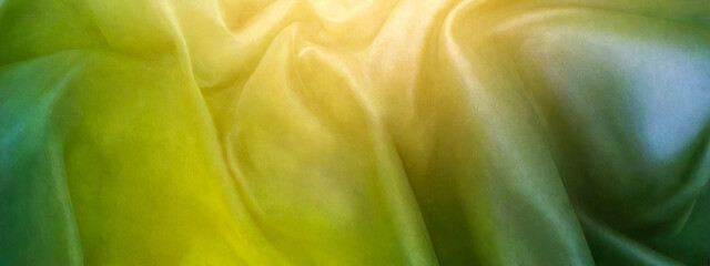 yellow green soft abstract background. folds of green fabric and warm sunlight. wide panoramic banner